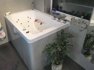An interior view of the specially adapted Nirvana soaking tub, complete with bespoke hydrotherapy system, coloured side panel and specially curved corner.